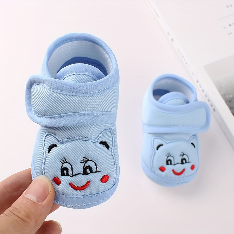 Cute baby walking shoes for boys and girls in light blue with cartoon faces, non-slip soles, and hook-and-loop closure. Ideal for first steps in any season.