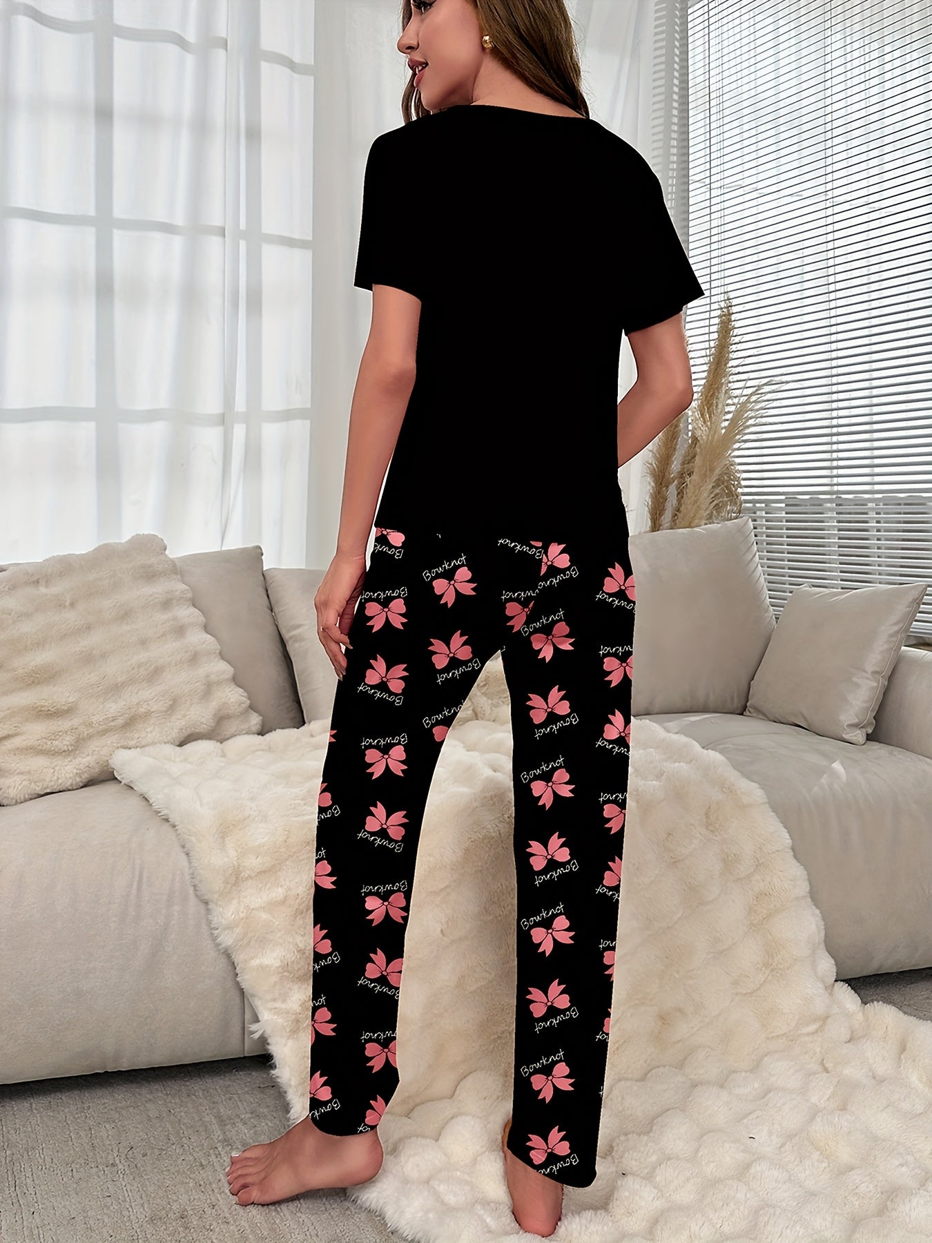 Women's sleepwear set with bow & slogan print, short sleeve top, and elastic pants.