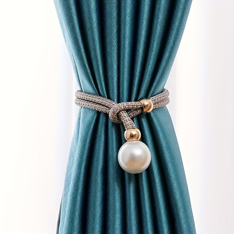 A faux pearl curtain tieback, perfect for holding back your living room curtains and adding a touch of elegance to your home or office decor. This decorative accessory is a stylish way to keep your curtains neatly stored when not in use.