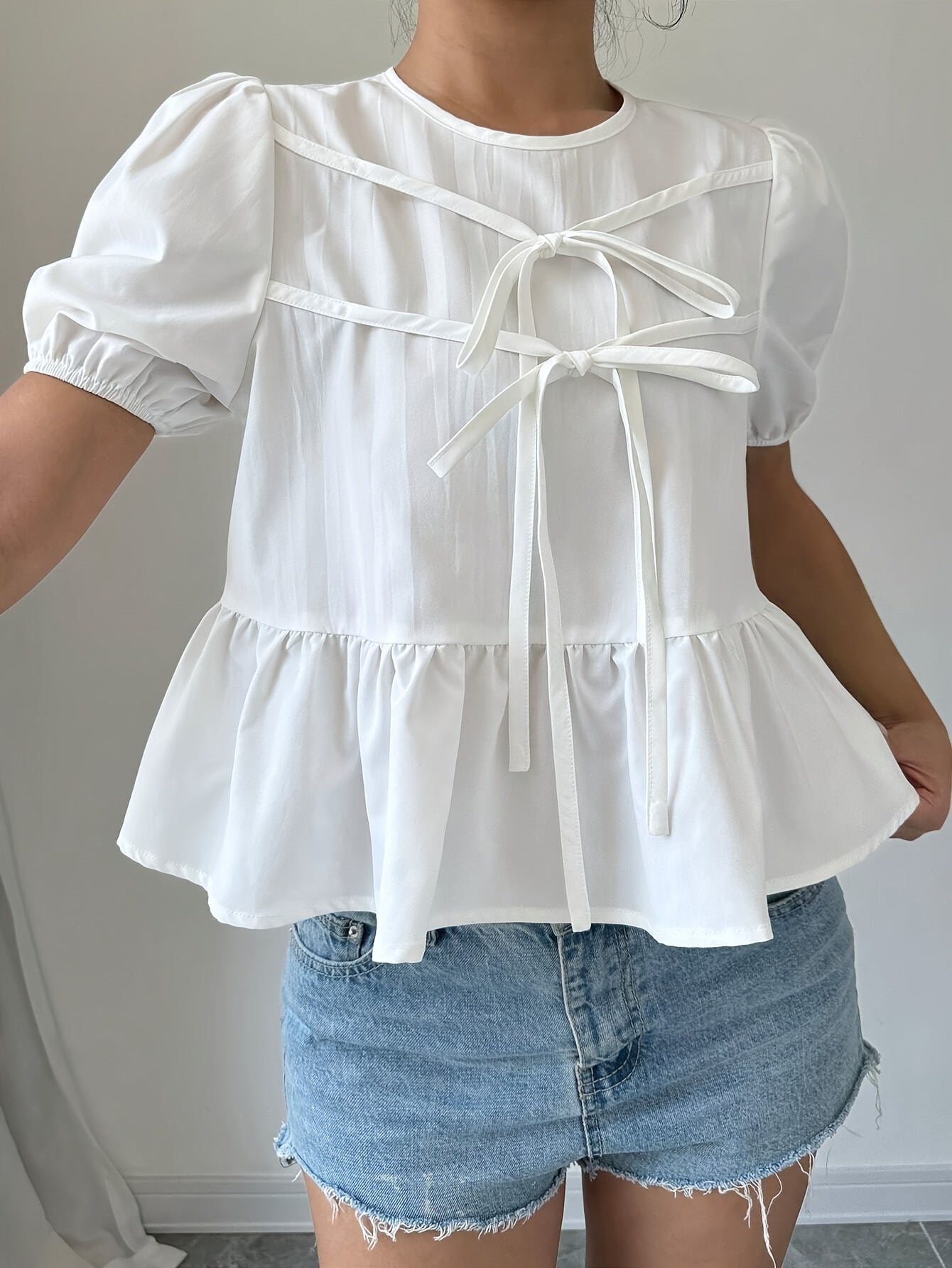 Puff-sleeve shirt with ruffles and front bow tie.