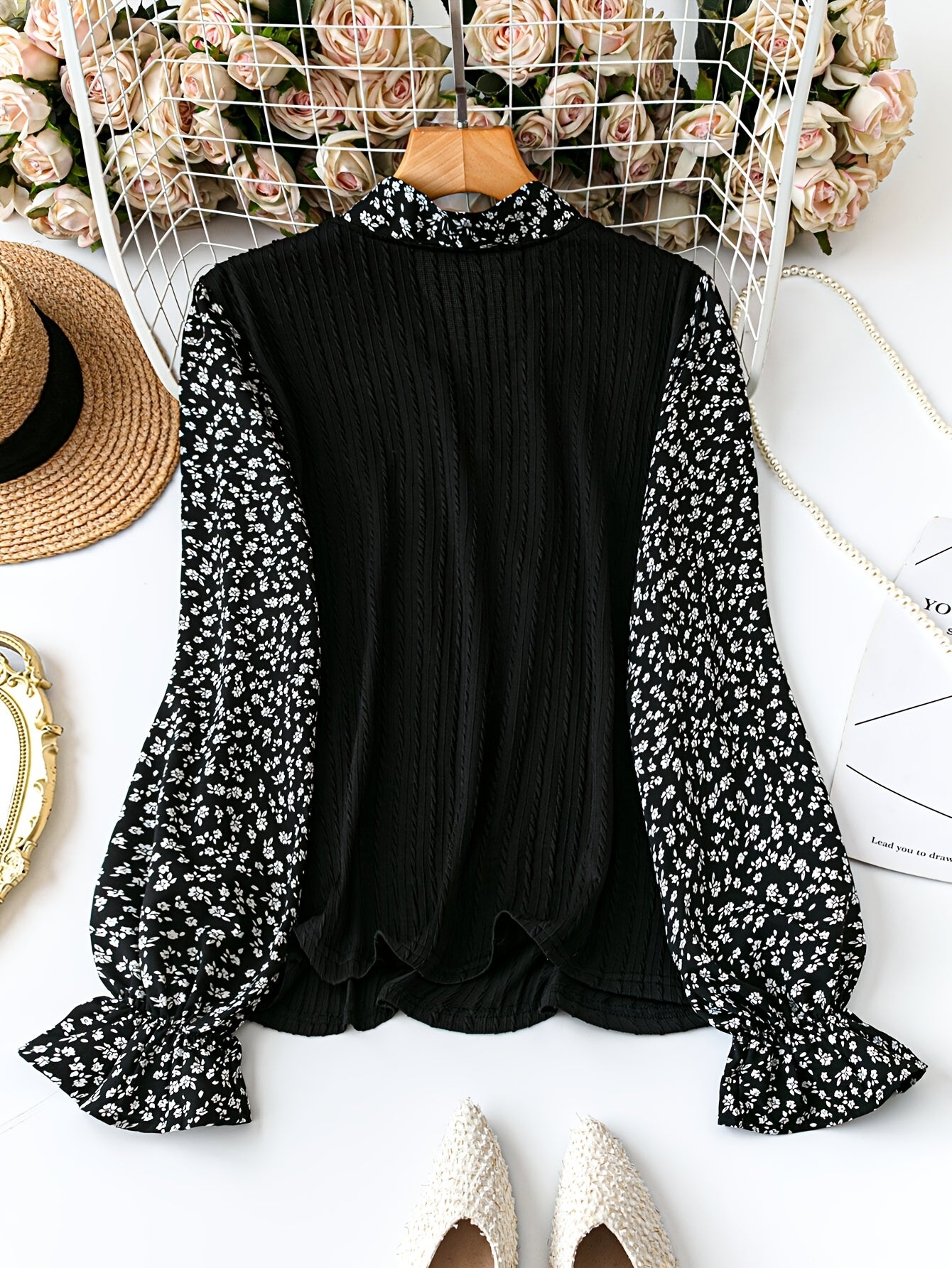 Stylish black and white long sleeve top with floral bow front, ruffled cuffs and hem, made of stretchy polyester blend. Suitable for all seasons.