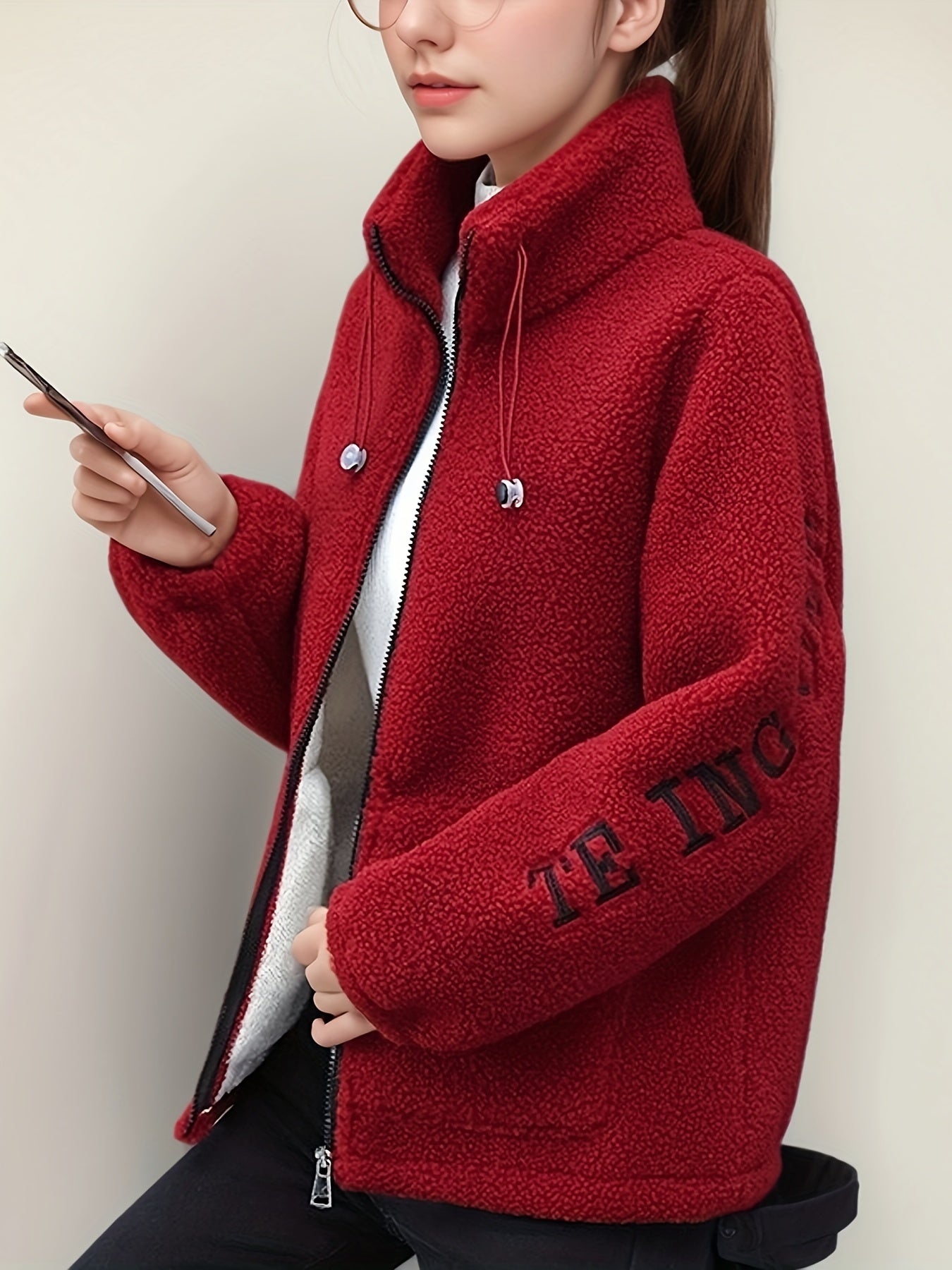 Cozy fleece-like jacket for women with embroidered letters in warm red velvet, perfect for all seasons. Cute and casual with a stand collar, long sleeves, and fleecelike texture.