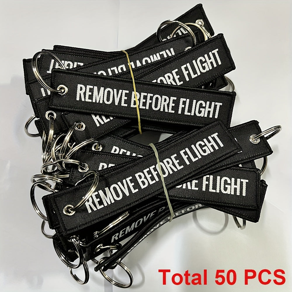 Bundle of 50 'Remove Before Flight' Woven Keychains made from sturdy polyester material - Ideal present for pilots and aviation fans, featuring the iconic phrase "REMOVE BEFORE FLIGHT