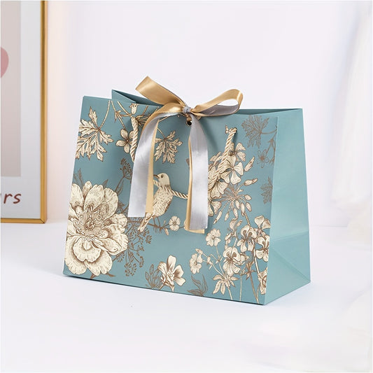 Floral paper gift bag with golden ribbon, teal background, brown, white & gray flowers, suitable for birthdays, weddings, Mother's Day, and special occasions. Features drawstring closure.