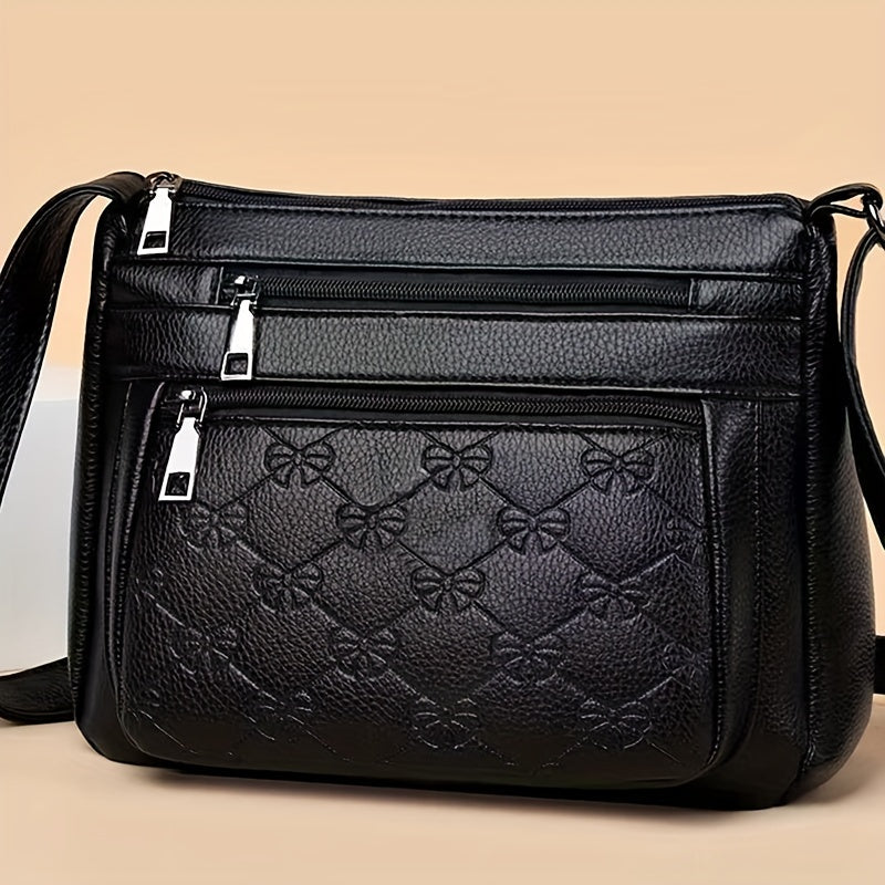 Chic black crossbody bag for women, featuring embossed floral design and bow accent. Ideal for daily use.