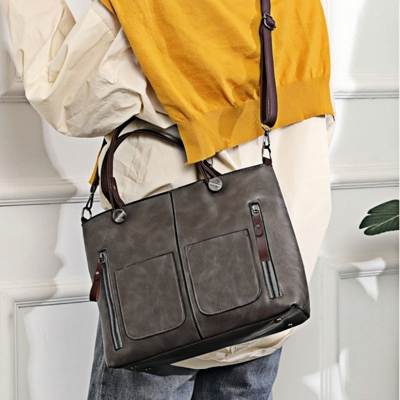 Vintage-style women's tote bag with adjustable strap, large capacity, multiple pockets, zipper closure, deep brown.