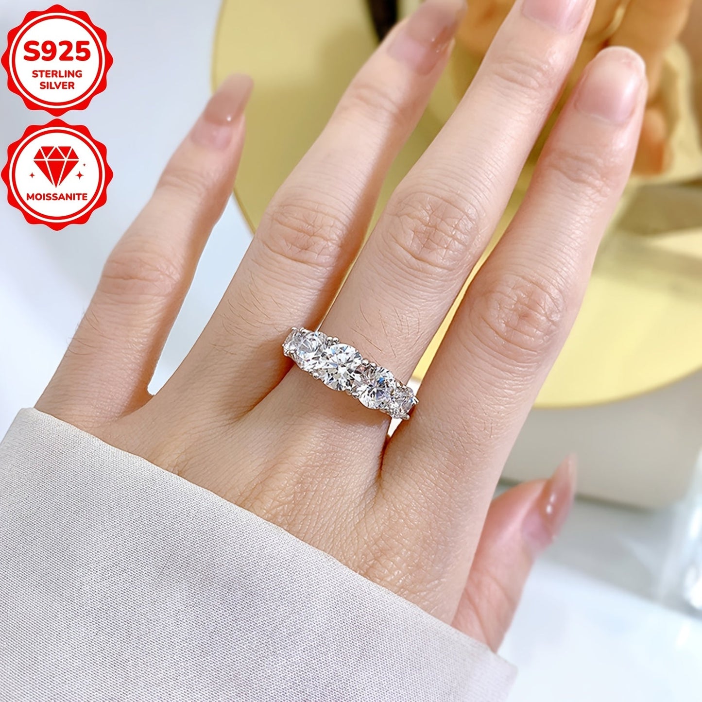 Ushbu ayollar uchun uzuk 925 sterling kumushdan tayyorlangan bo'lib, go'zal moissanite toshlari bilan bezatilgan. Uzukda 6.5mm markaziy tosh, ikkita 6mm tosh va ikkita 5mm tosh mavjud bo'lib, jami 3.60ct. Har bir tosh ehtiyotkorlik bilan o'rnatilgan.