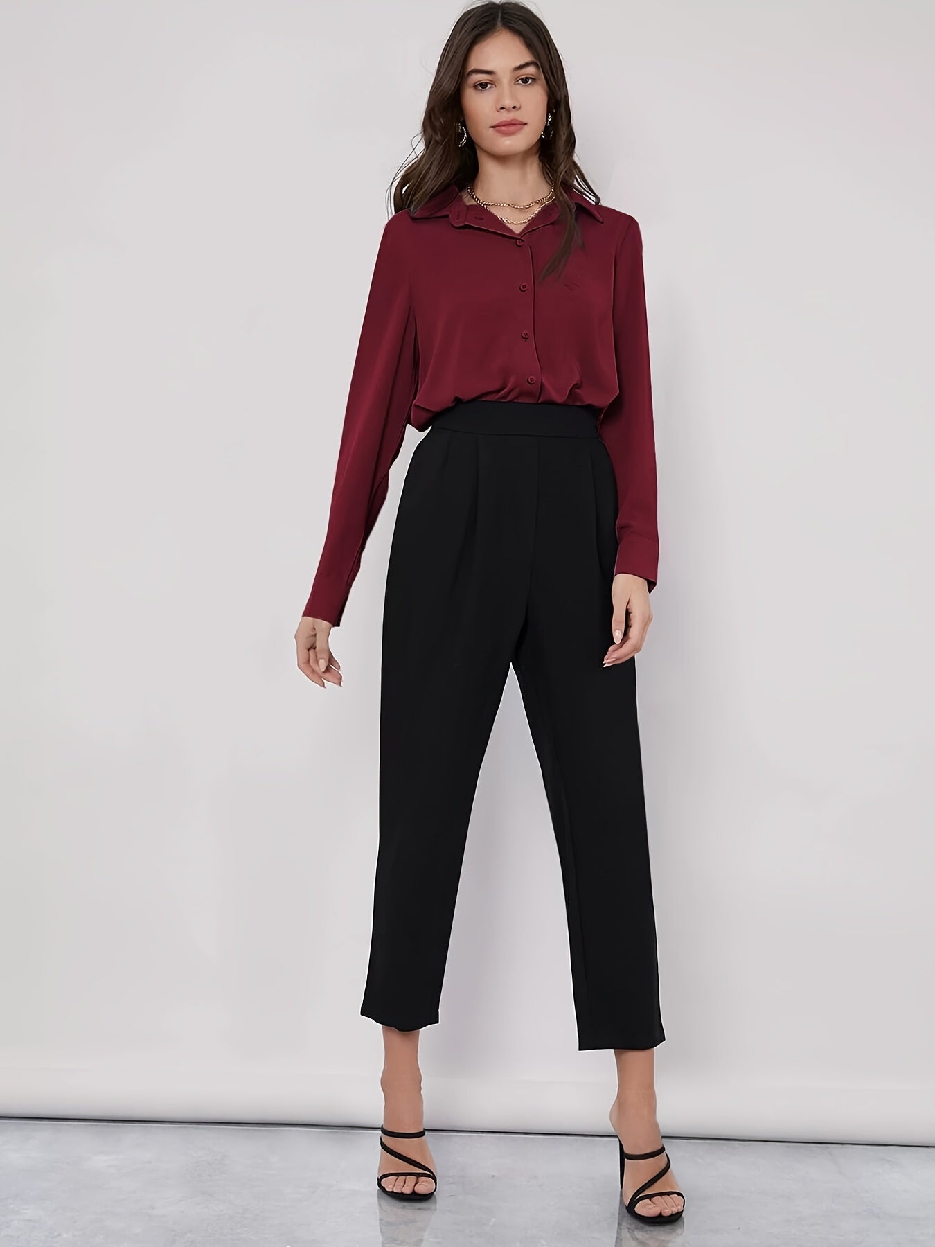 Stylish maroon button-up blouse for women, with long sleeves, curved hem, and made of machine-washable polyester blend. Perfect for work or casual wear.