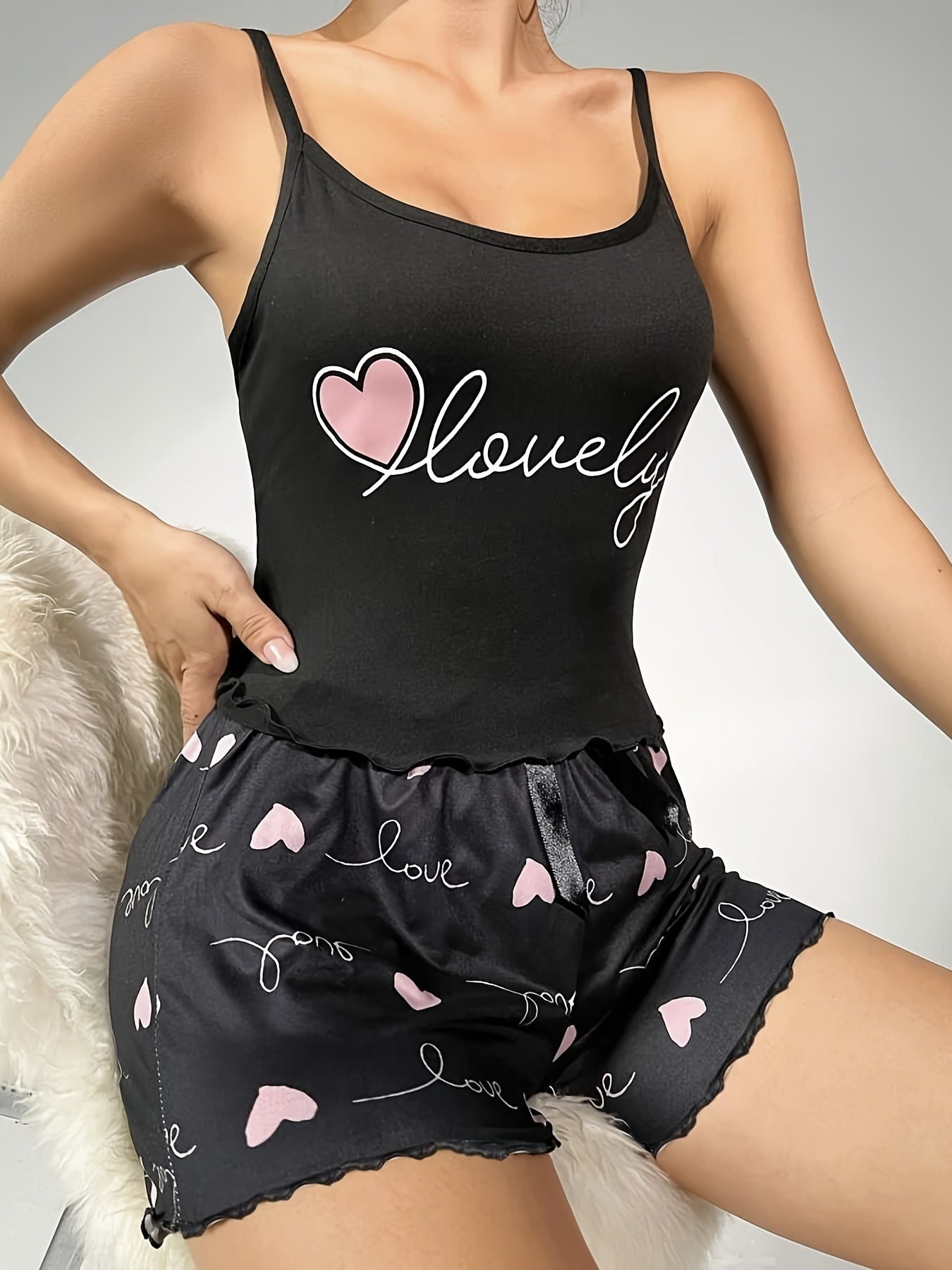 Women's sleepwear set with scoop neck cami top and lettuce trim shorts featuring letter and heart print design.