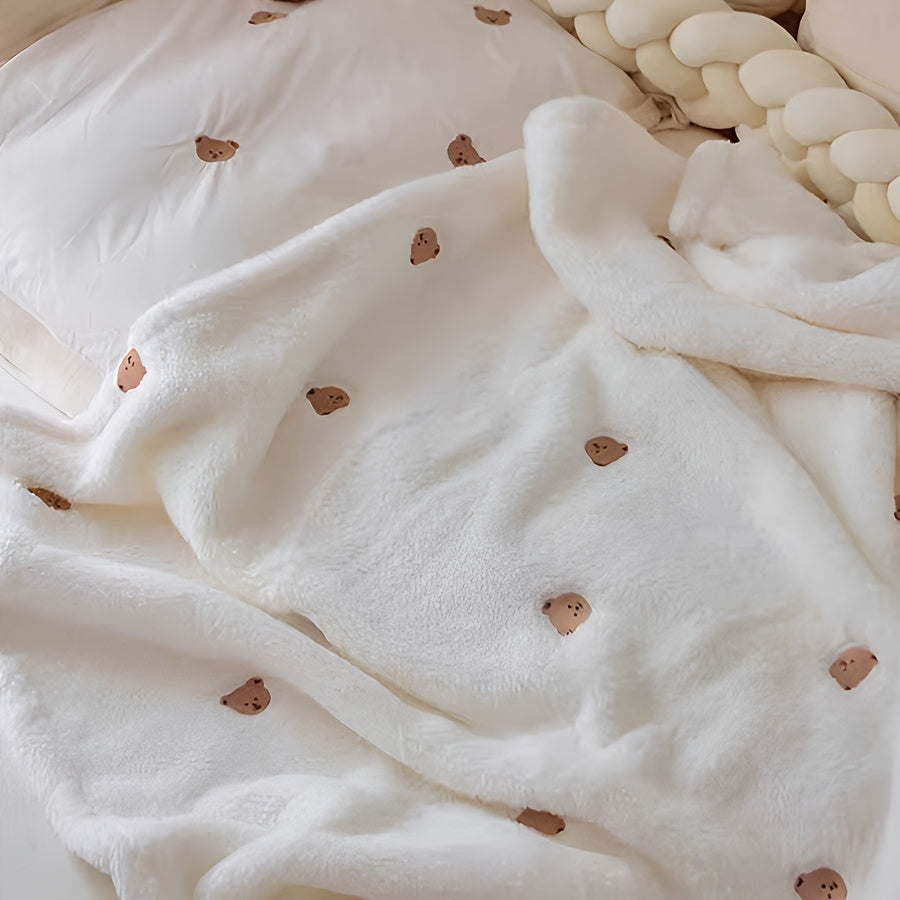 Soft polyester white blanket featuring an embroidered bear design, perfect for cozy youngsters.