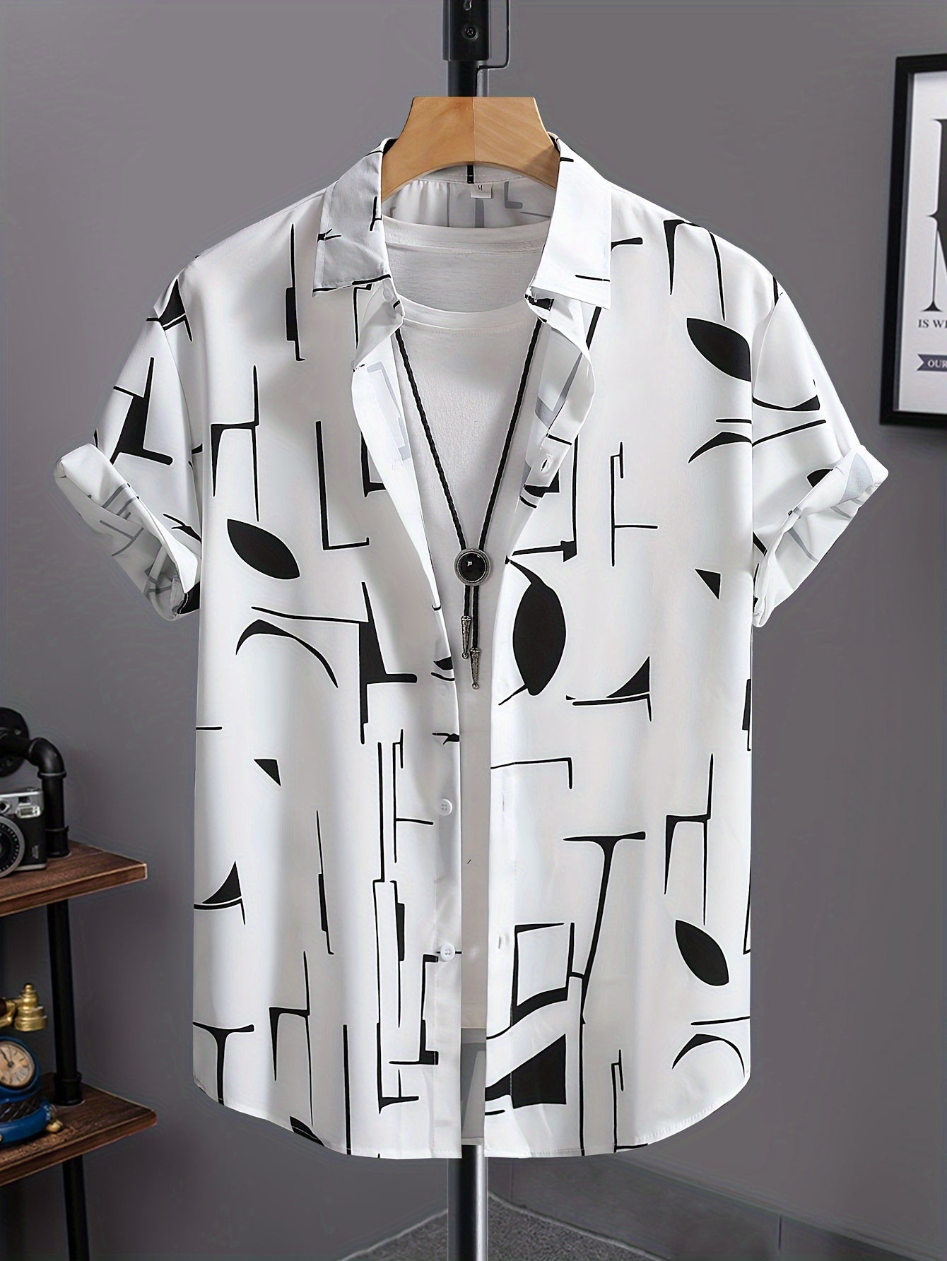 Casual geometric graphic print button-up shirt with lapels and short sleeves, paired with drawstring pants for outdoor activities.