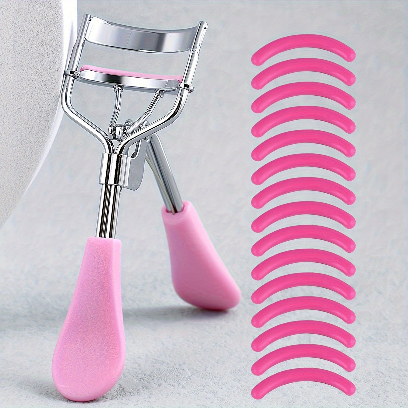 Portable eyelash curler with stainless steel handle, 15 silicone pads for curling and shaping without damaging lashes. Ideal for lifting and creating big, beautiful eyes on women.