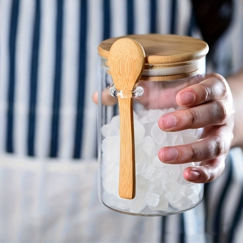 Glass airtight jars with bamboo lids and wooden spoons are versatile round food storage containers for the kitchen. They are reusable, easy to hand wash, and feature a flip top closure. Perfect for storing sugar, spices, and dry goods.