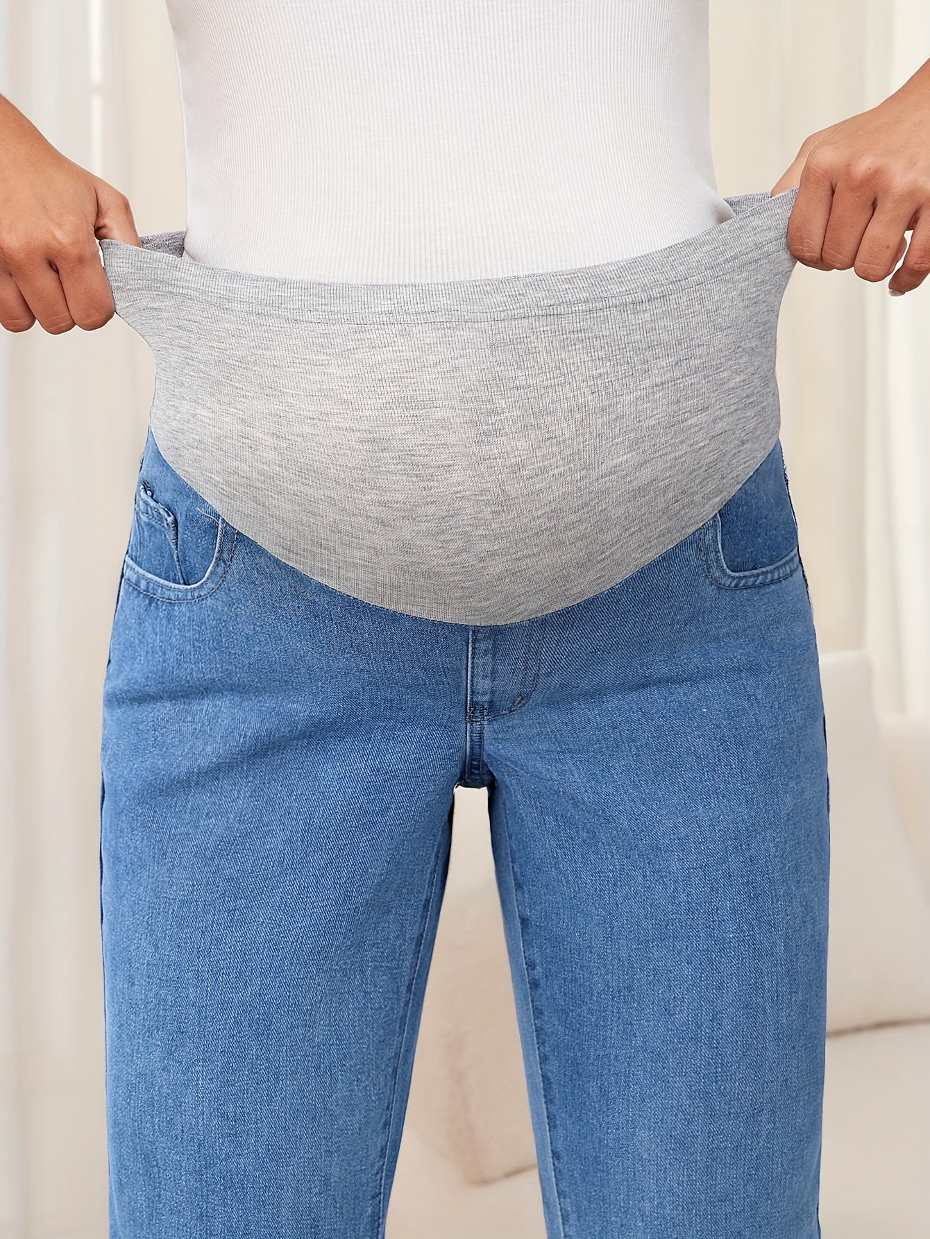 Maternity jeans in a washed denim style with a loose fit and straight leg. Made from 65% cotton and 35% polyester, these non-stretch pants feature a solid color and mature style perfect for