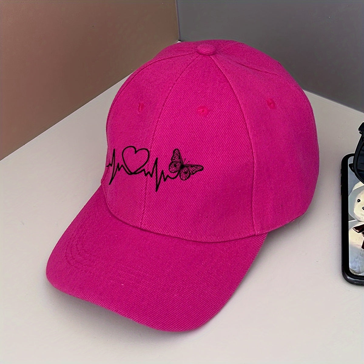 Pink baseball cap with butterfly design for outdoor events and sun protection.