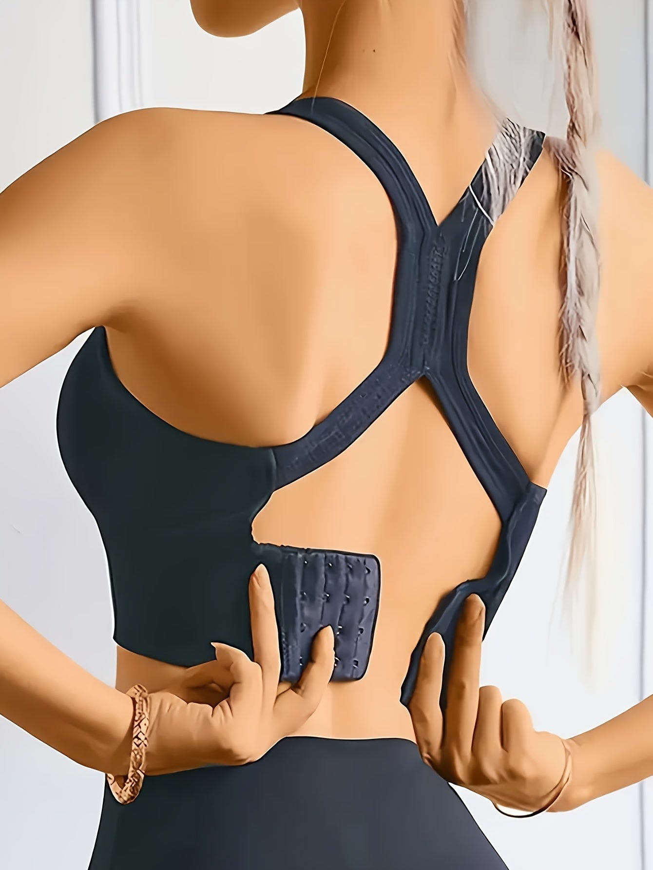 High-support sports bra for women with adjustable back buckle, removable pads, and cross-back design. Great for yoga, fitness, and running. Made with breathable nylon fabric.