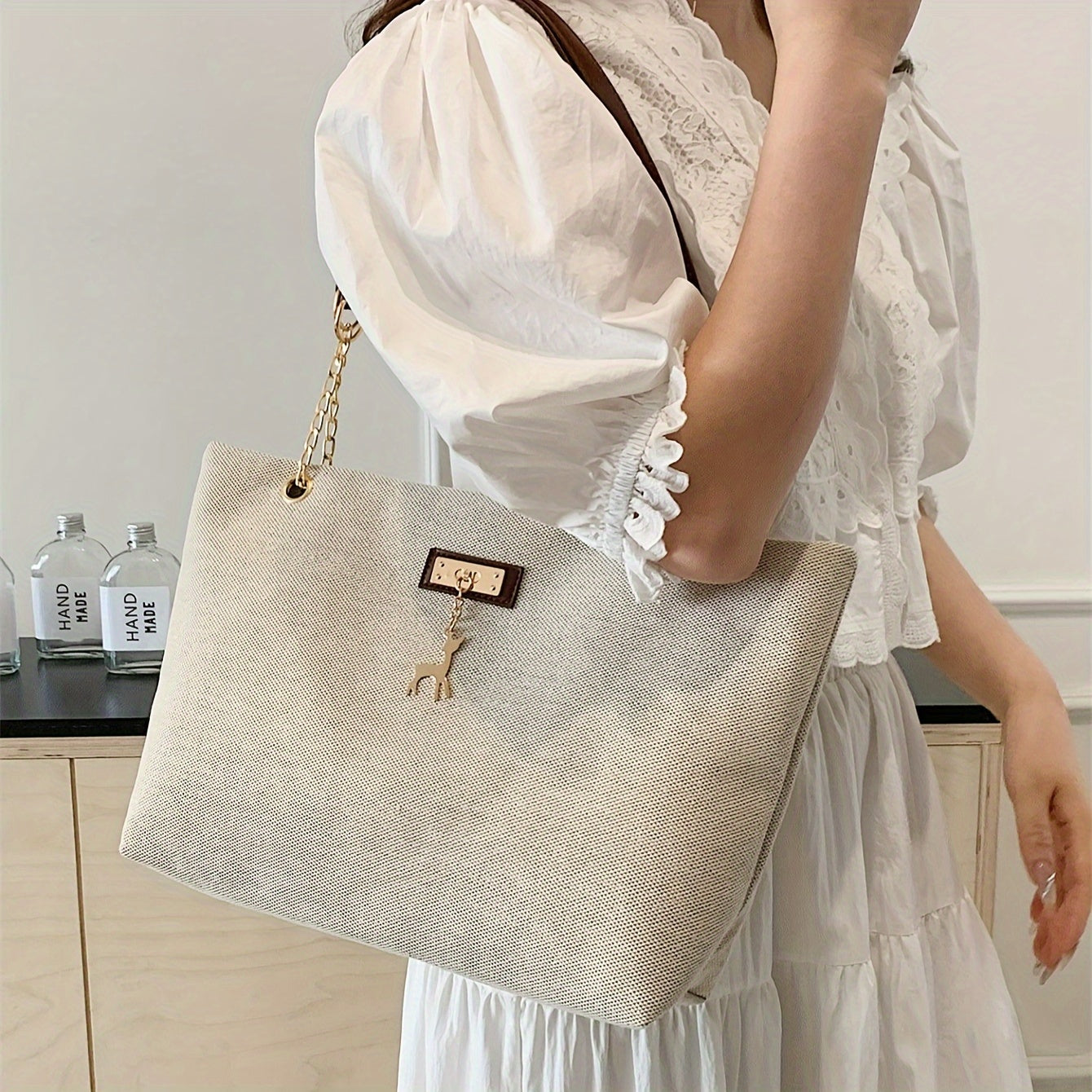 Polyester tote bag for women with deer charm, adjustable strap, zipper closure, painted edges, and messenger bag style.