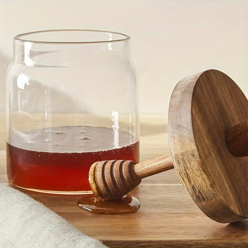 Premium honey jar with wooden stirring stick, made of high borosilicate glass for transparent honey storage.