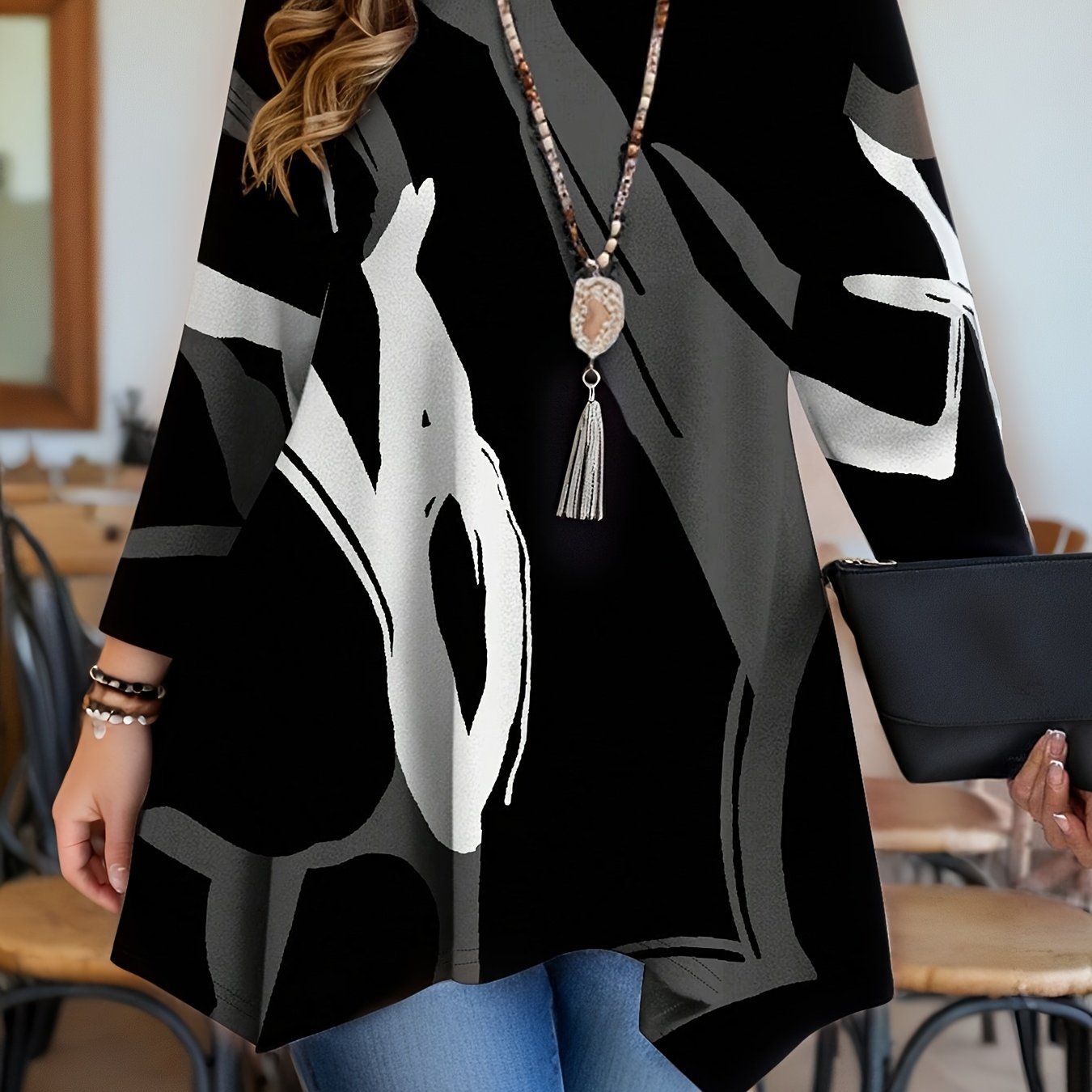 Women's plus size geometric print tunic top with asymmetrical hemline in black, red, white, and gray. Features long sleeves, round neck, and is machine washable. Made of polyester blend.