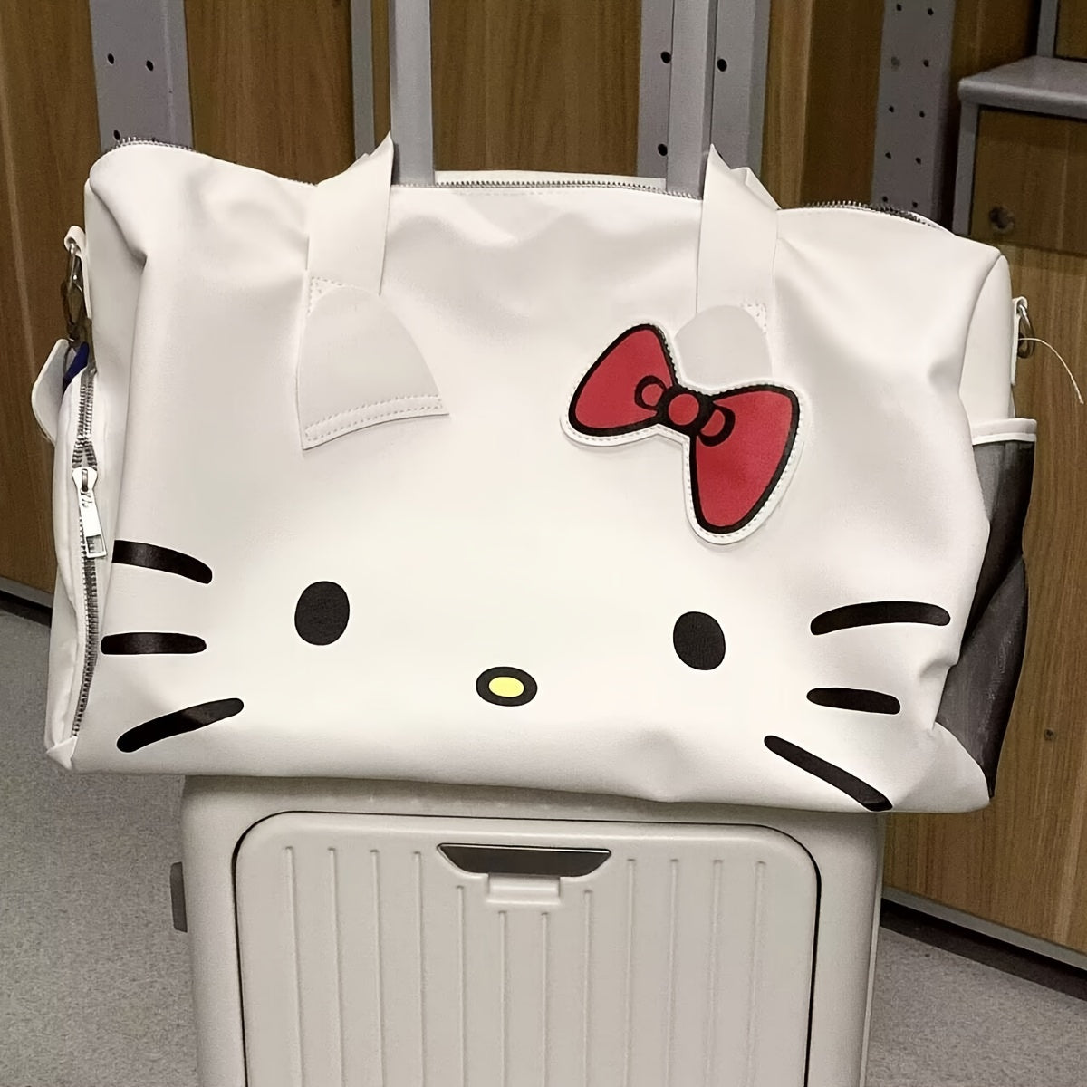 Sanrio Hello Kitty travel bag with adjustable strap, zipper closure, and animal print lining - White