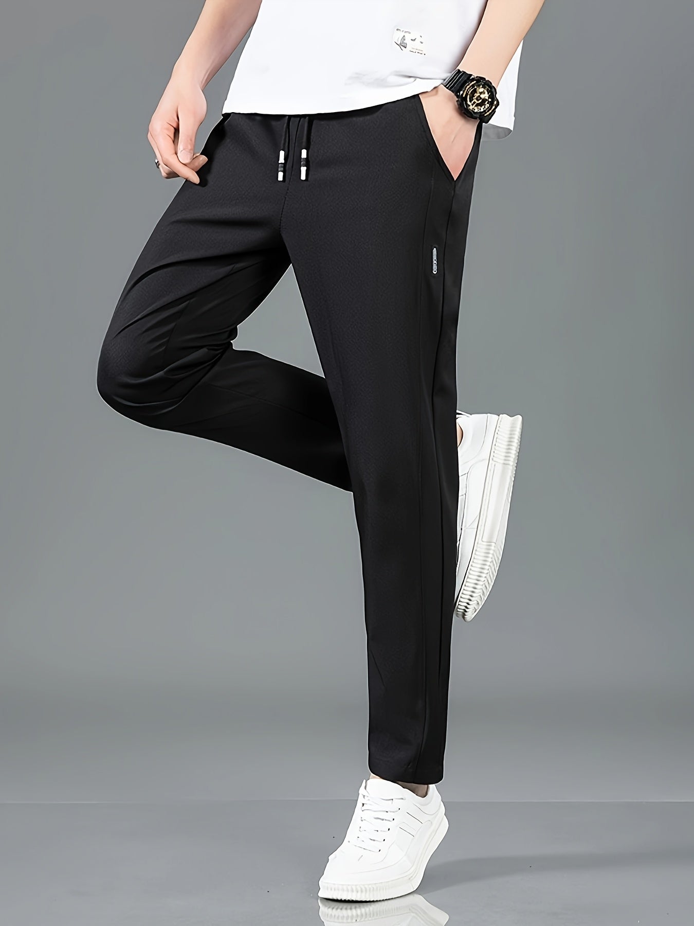 Men's casual drawstring pants, made of quick-dry, breathable polyester in solid colors with side pockets. Suitable for all-season outdoor activities and hiking in black and navy blue.