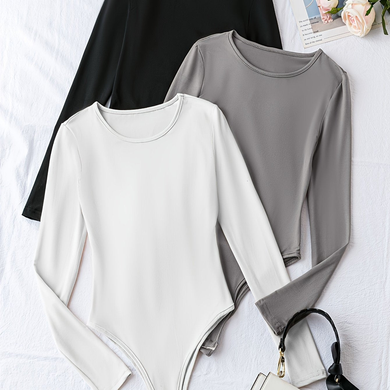 Pack of three solid crew neck long sleeve bodysuits for women. Casual one-piece clothing.