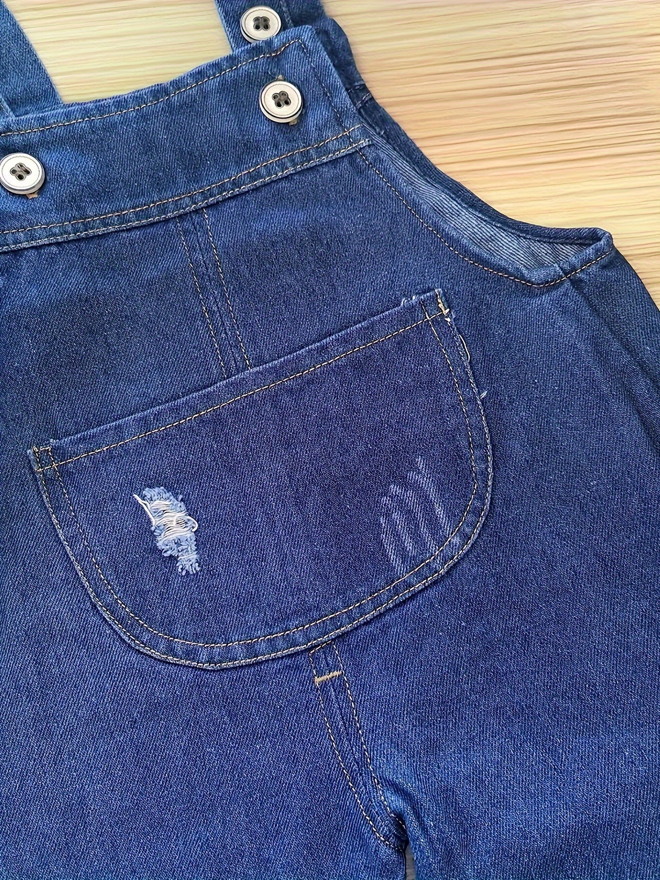 Infant & toddler girl's denim jumpsuit with pocket patches and ripped overalls, perfect for spring and summer.