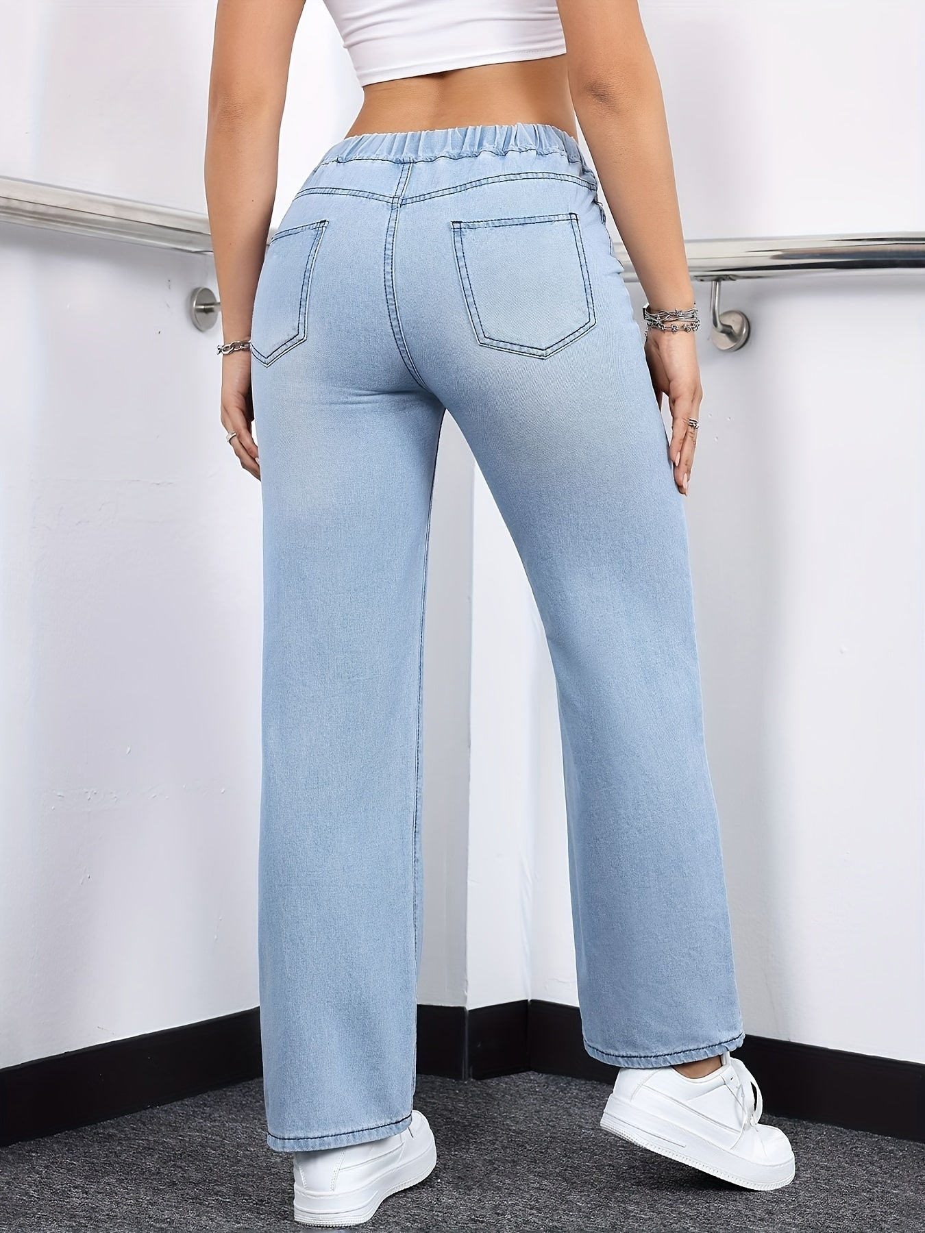 Women's stylish washed blue jeans with elastic waistband, made from comfortable polyester blend denim, suitable for all seasons.