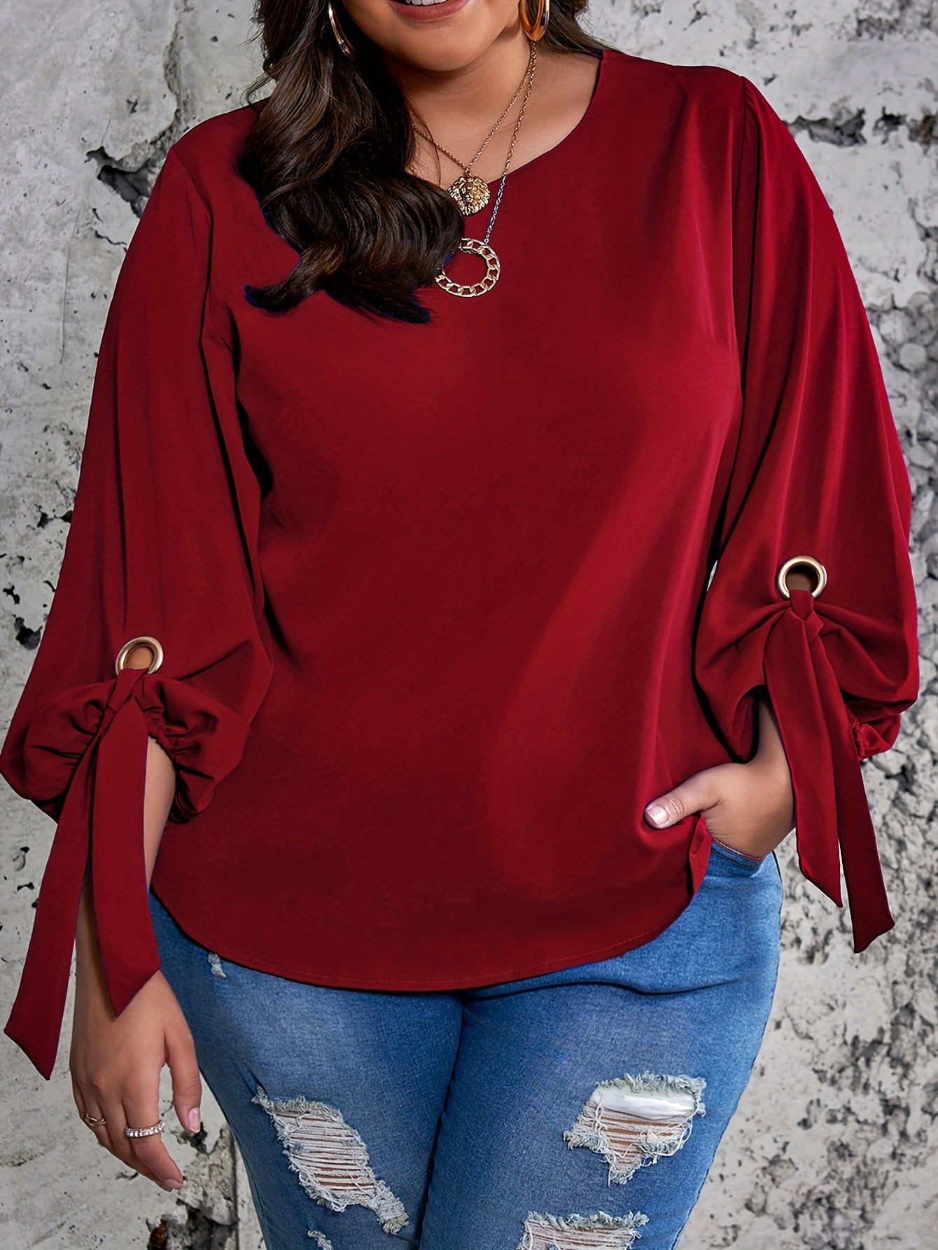 Plus size women's casual top with solid colors, lantern sleeves, round neck, round hem, and knot detail.