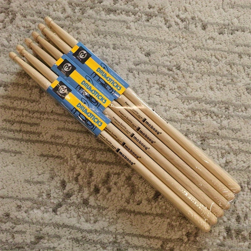 Set of 12 pairs of 5A/7A oak drumsticks for percussion instruments, jazz drumming, and electronic drums. Premium wood grain design for beginners and professional drummers. Labeled as