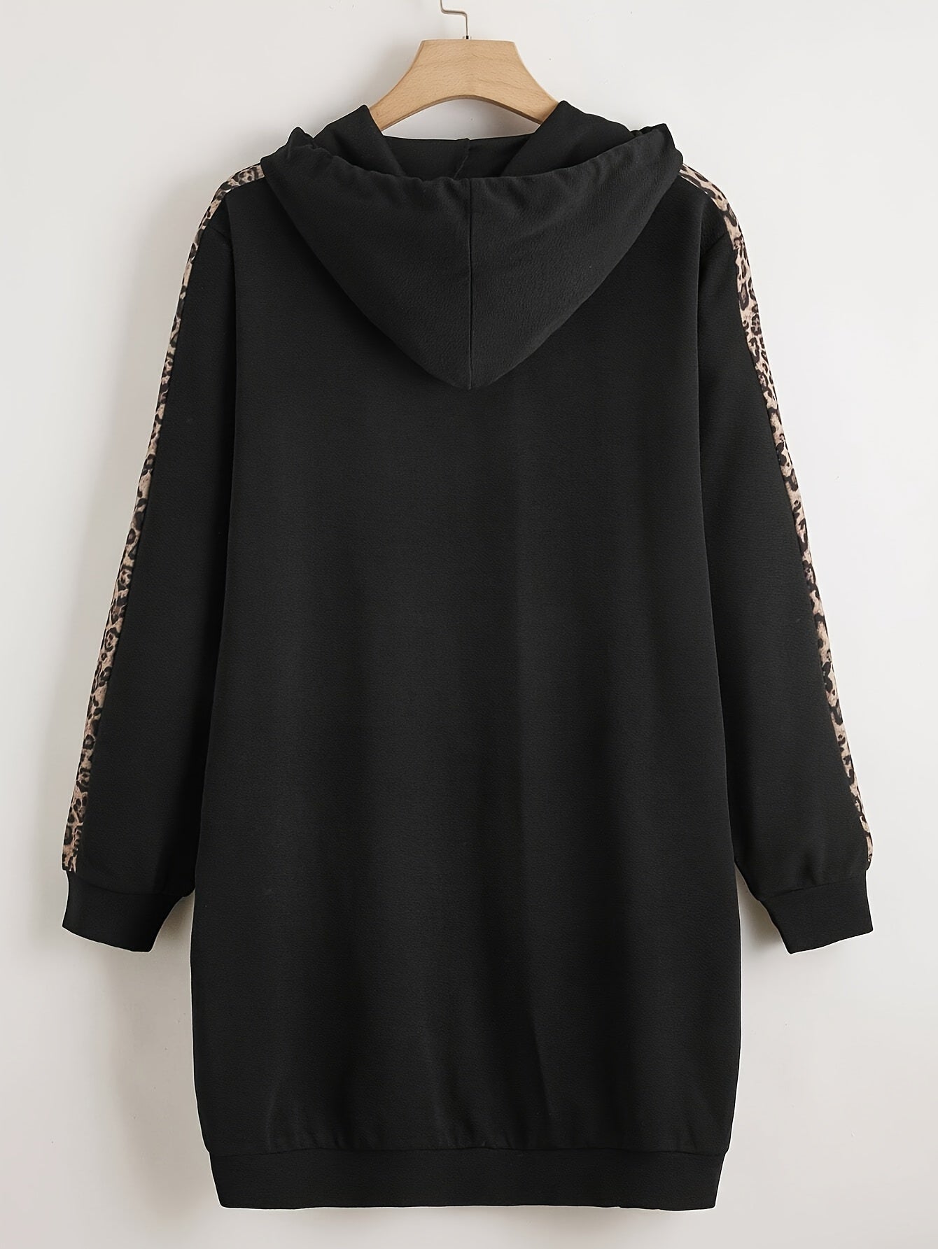 Black hoodie with leopard print accents, long sleeves, drawstring hood, and pockets. Made from polyester knit, oversized fit.