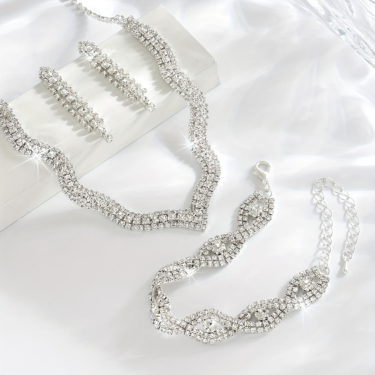 This elegant white jewelry set includes a stunning necklace, a pair of exquisite earrings, and a delicate bracelet, making it the perfect accessory for wedding parties and bridal gowns.