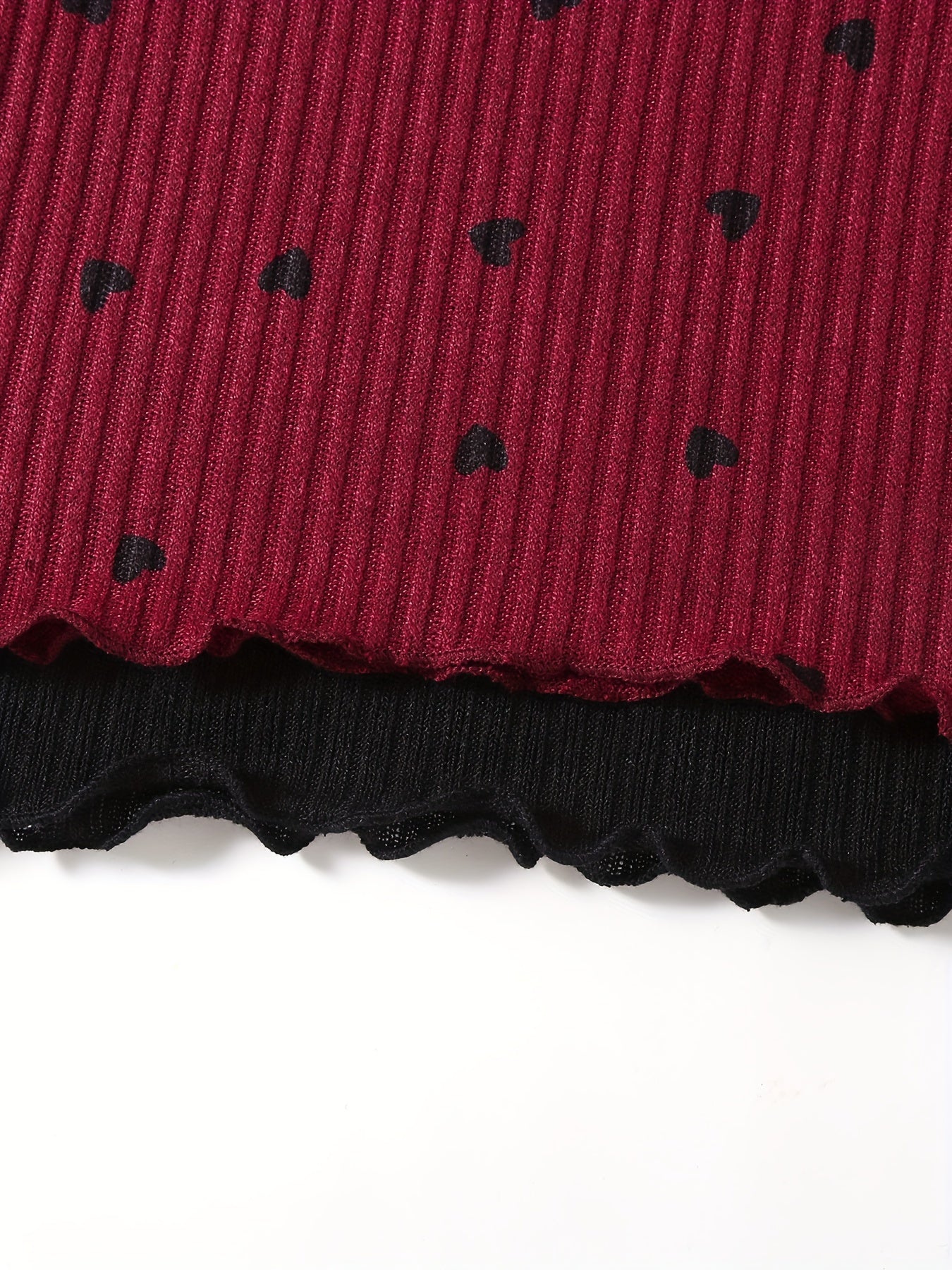 2 girls' ribbed knit outfits in black and red, with ruffled edges. Machine washable. Ideal for outdoor wear.