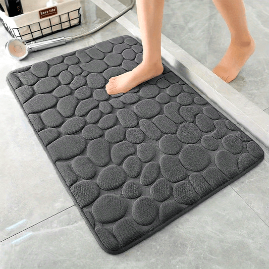 Soft and comfortable memory foam bath rug featuring cobblestone embossment. Rapid water absorbency and washable. Non-slip bathroom accessory.