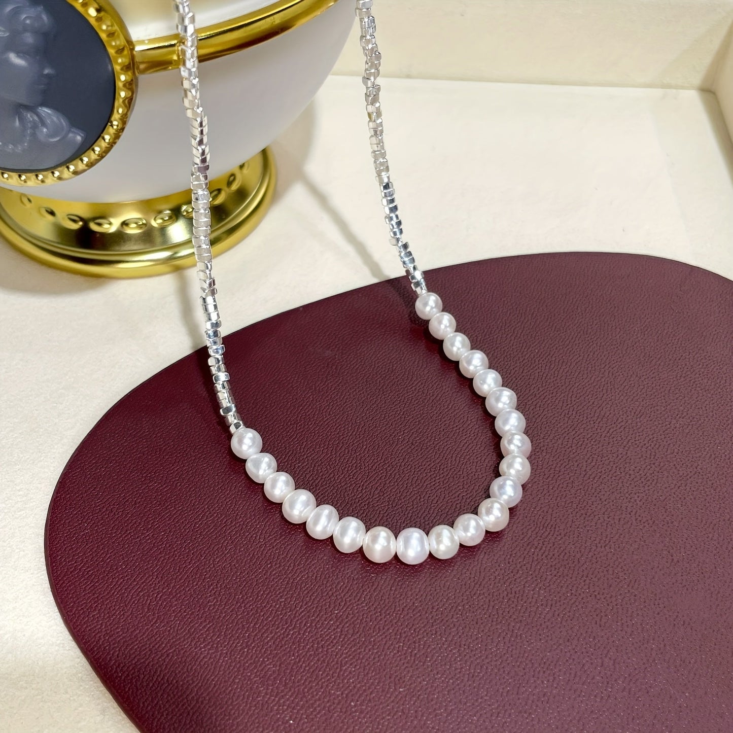 This elegant and versatile necklace features a natural freshwater pearl set in 925 sterling silver. Perfect for women who appreciate timeless glamour and chic style, this piece is ideal for gifting to loved ones or treating yourself. With its 18K gold