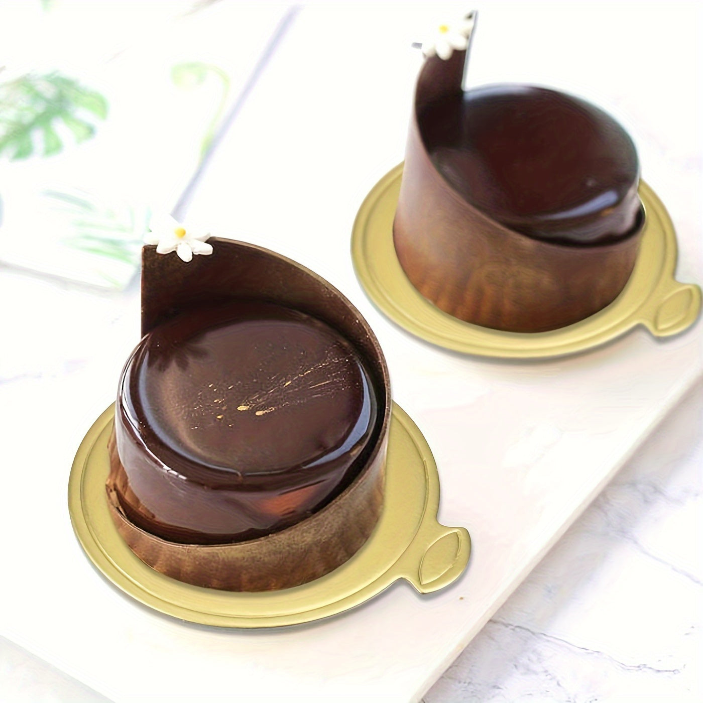 Golden cardboard mini cake bases, ideal for serving mousse desserts at weddings, birthday parties, and other special occasions. Each pack includes 50/100 round disposable paperboard cupcake boards for elegant party displays.