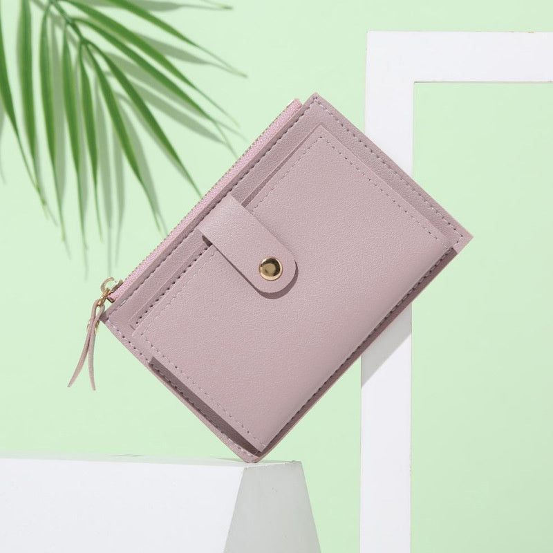 Slim short wallet for women with zipper closure, bifold design, credit card slots, coin purse, and solid color.