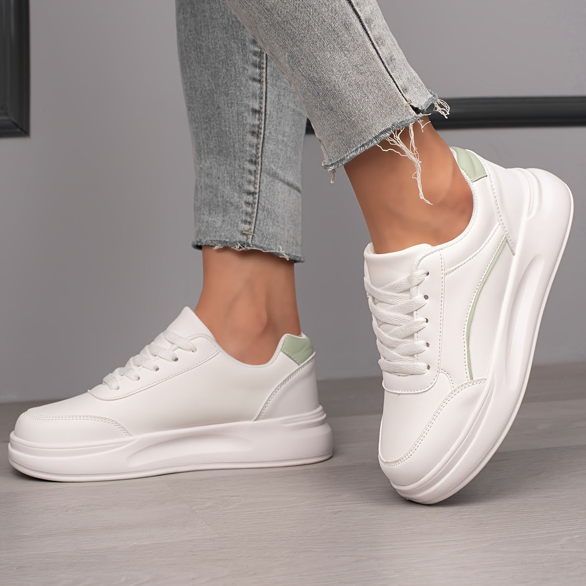 Women's white skate shoes with round toe, lace up closure, and low top flat design. Comfortable for casual wear and sports.