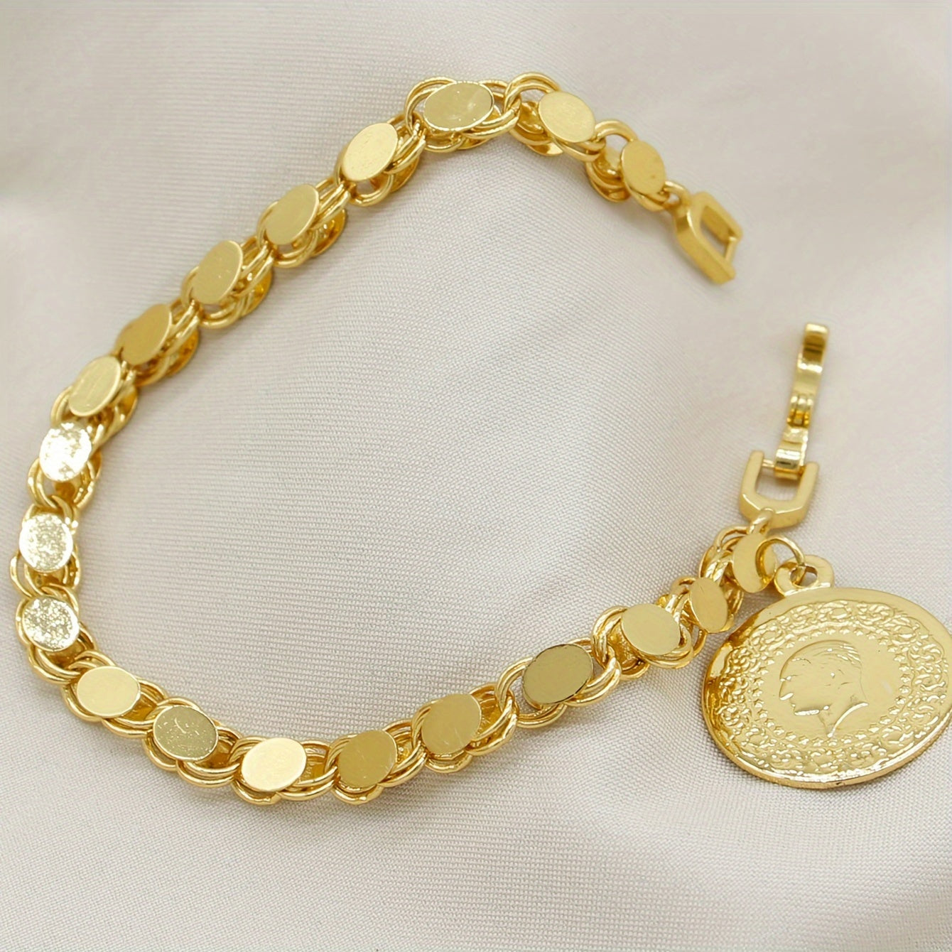 A handmade bracelet adorned with a gold-plated Turkish lira pendant, perfect for everyday or special occasions.