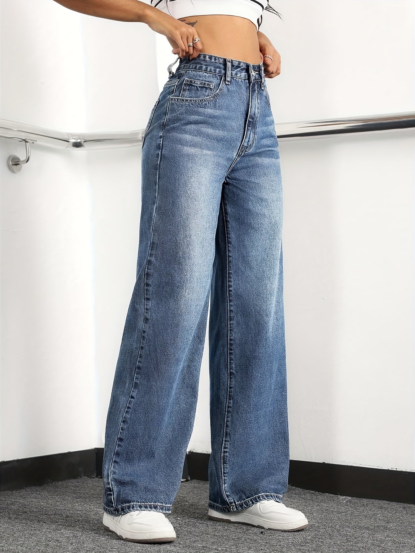 Women's wide leg jeans with high waist and washed details, suitable for casual fashion.