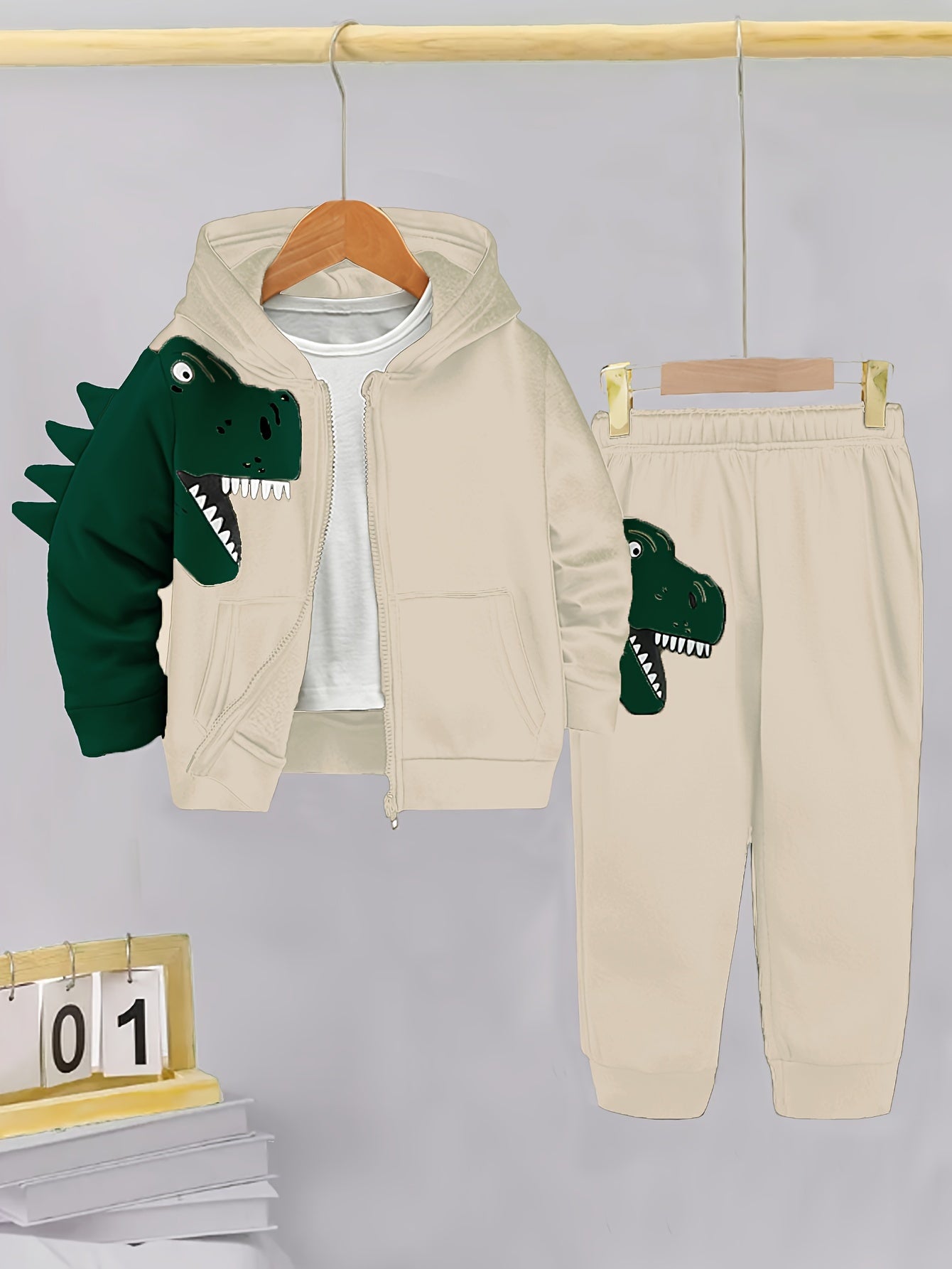 2-piece toddler set with fleece-lined hoodie and pants featuring dinosaur pattern. Perfect for autumn/winter outdoor activities, soft, cozy, and machine washable.