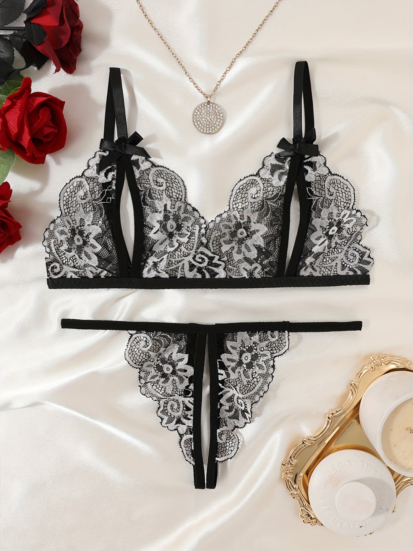 Floral lace lingerie set with cupless bralette, bow detail, crotchless thong panty, and intimate boudoir wear.