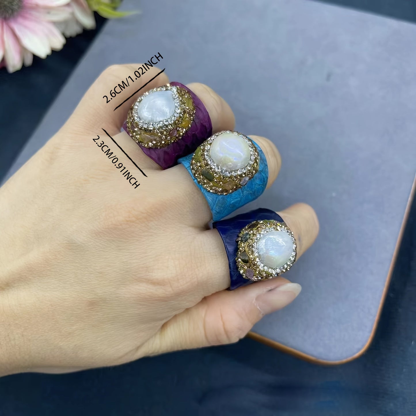 Casual yet sophisticated, this Boho-chic ring features genuine faux leather and snakeskin accents, along with a stunning baroque pearl and tourmaline. The adjustable open design adds versatility to your everyday attire.