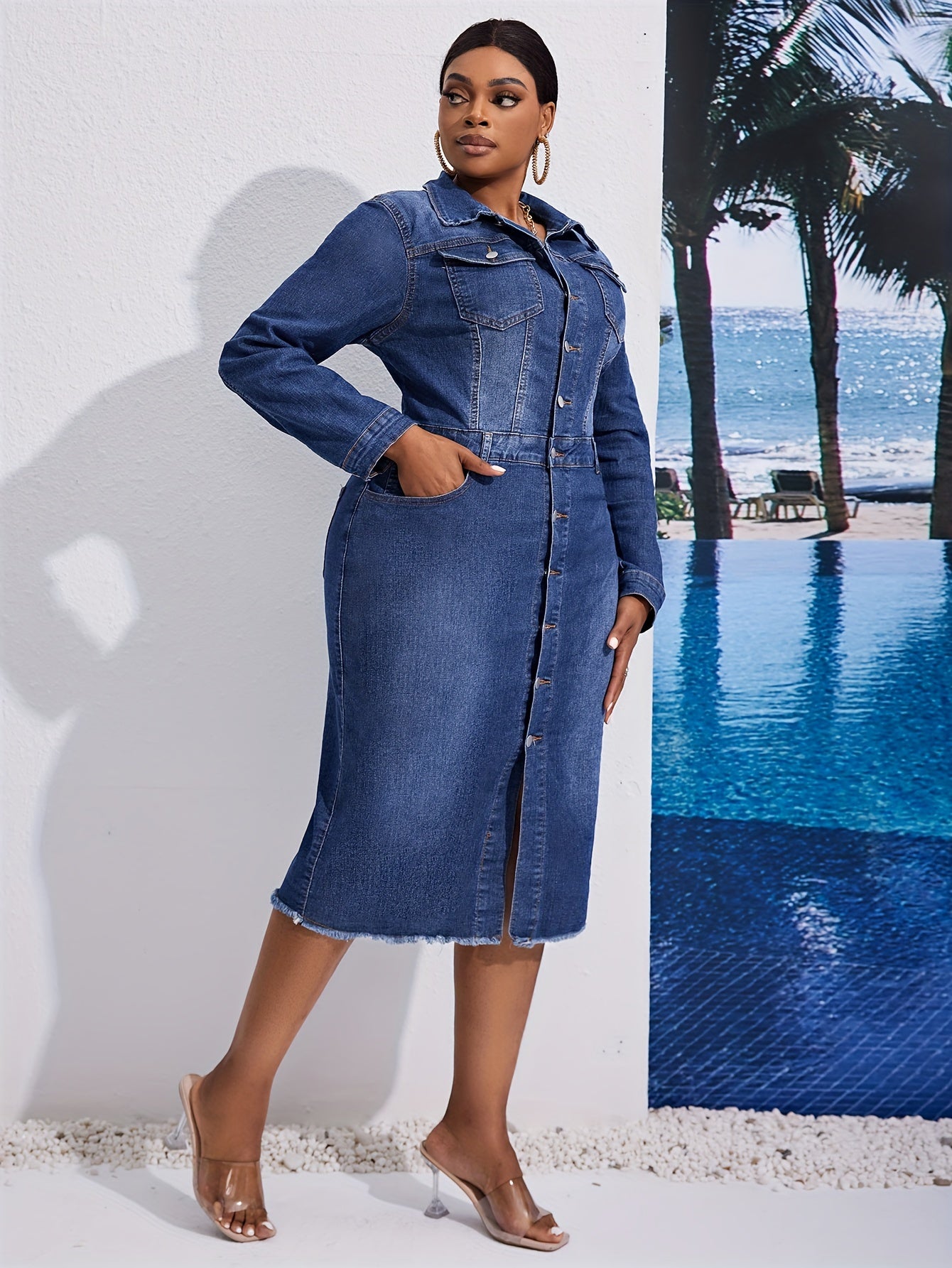 Kiki Angel offers a plus-size denim midi dress with a button-front, lapel collar, and frayed hem. Made from a cotton blend fabric, this solid color tunic is perfect for casual style in