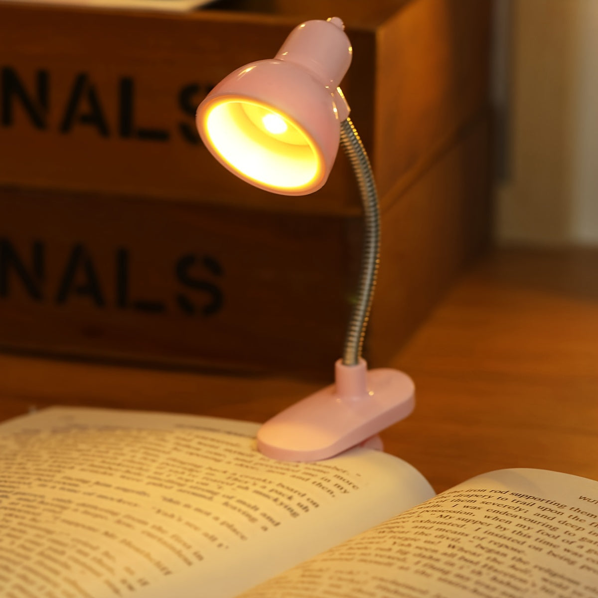 Mini portable LED book light with adjustable arm, warm light for night reading.