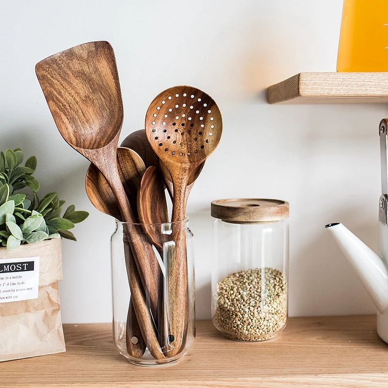 Set of 4/7 pieces of kitchen tools made from natural teak wood from Thailand, including spoons, ladles, turners, colanders, skimmers, and scoops, suitable for cooking and serving in the kitchen.