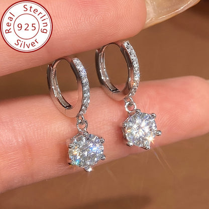 Elegant and luxurious 925 silver earrings designed with six prongs and inlaid with shiny 1ct Moissanite. Perfect for ladies, ideal for special occasions like banquets, anniversaries, or birthdays. A fashionable and delicate accessory weighing 2.6g.