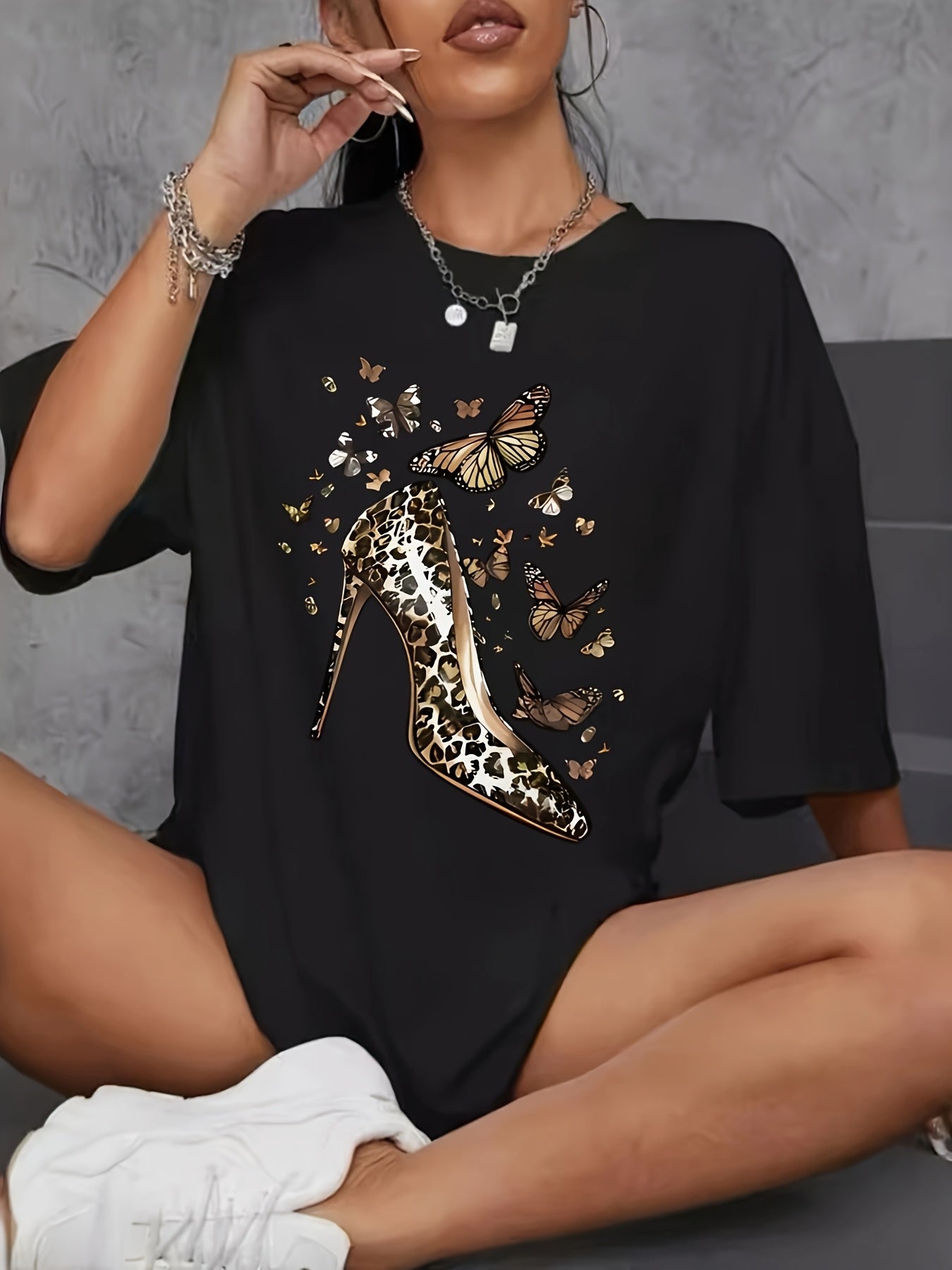 Plus size women's short sleeve t-shirt with geometric high heel and butterfly print, crew neck, asymmetrical design, polyester knit fabric, medium stretch, perfect for spring/summer.