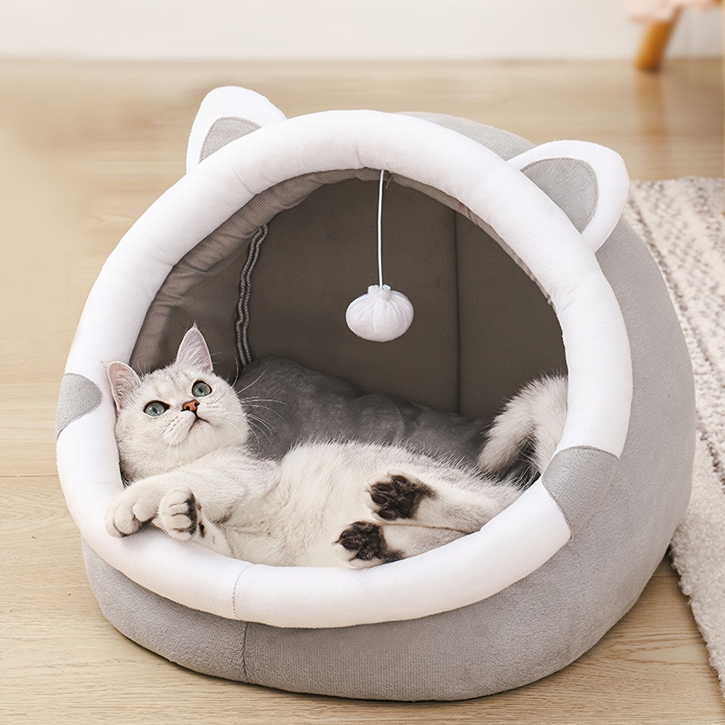 Convertible grey cat ear pet bed made of polyester fiber material. Suitable for small to medium cats and dogs. All-season indoor sleeping lounge with dangling ball toy.