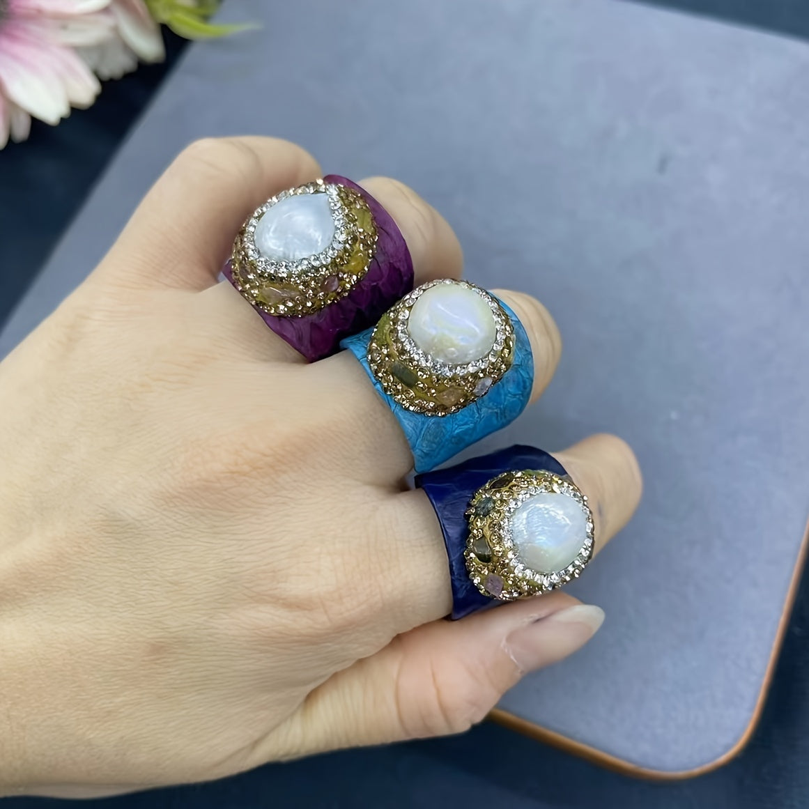 Casual yet sophisticated, this Boho-chic ring features genuine faux leather and snakeskin accents, along with a stunning baroque pearl and tourmaline. The adjustable open design adds versatility to your everyday attire.